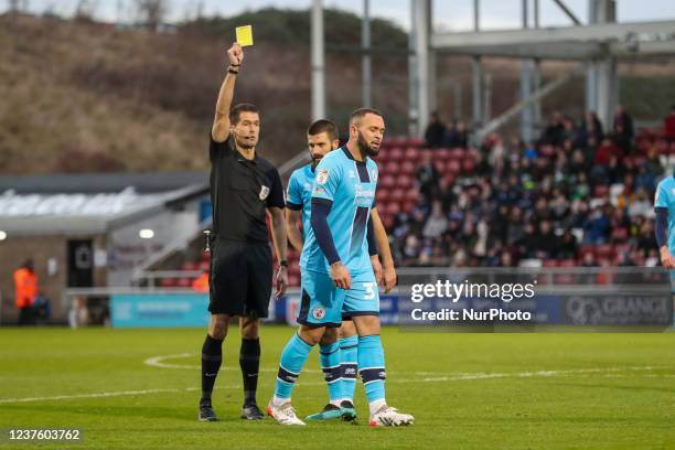 Referee Declan Bourne shows a yellow card to Crawley Town's Joel Lynch during the first half of the Sky Bet League 2 match between Northampton Town...