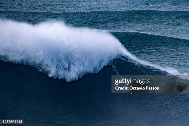 Big wave surfer Pedro Scooby from Brazil rides a wave during a surfing session at Praia do Norte on January 8, 2022 in Nazare, Portugal.