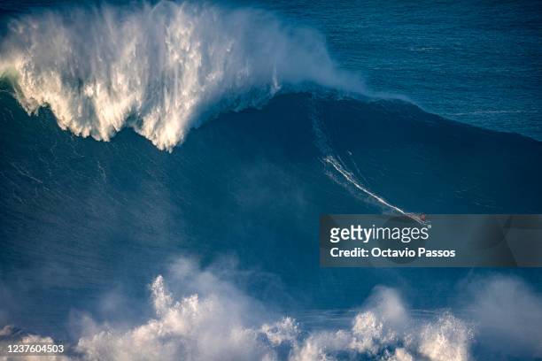 Big wave surfer rides a wave during a surfing session at Praia do Norte on January 8, 2022 in Nazare, Portugal.