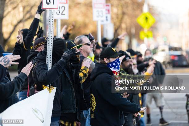 Members of the Proud Boys make the "OK" symbol with their hands as they pose in front of the Oregon State Capitol building during a far-right rally...