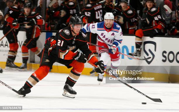 Isac Lundestrom of the Anaheim Ducks skates with the puck with pressure from Barclay Goodrow of the New York Rangers during the game at Honda Center...