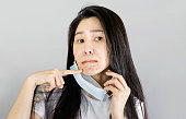 Young Asian woman wearing medical face mask and white t shirt. isolated on gray background,health care concept