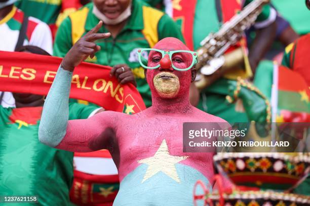 Football fan painted with the colours of the Burkina Faso national flag gestures ahead of the opening ceremony of the Africa Cup of Nations 2021...