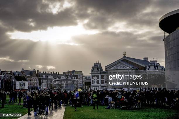 People gather at the Museumplein in Amsterdam during a demonstration called by "the Netherlands in Resistance" movement on January 9 against the...