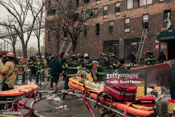 Emergency first responders remain at the scene of an intense fire at a 19-story residential building that erupted in the morning on January 9, 2022...