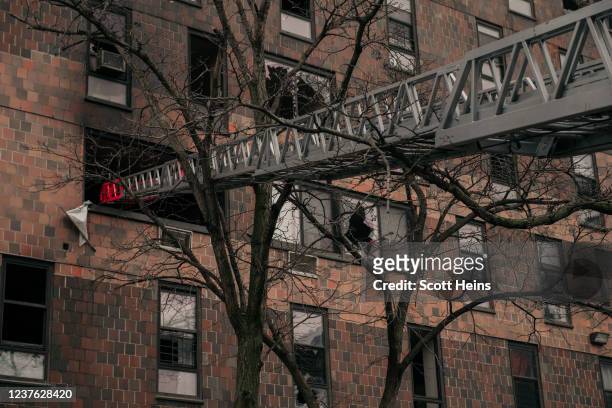 Broken windows and charred bricks mark the exterior of a 19-story residential building after a fire erupted in the morning on January 9, 2022 in the...