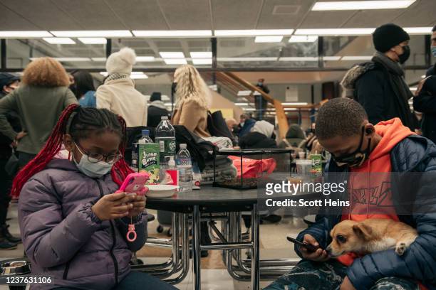 Jayden Mance and her brother Jordan , take refuge with their pet gecko, Echo and dog Kai at a school cafeteria after a fire at their apartment...