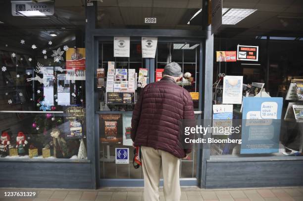 Pedestrian checks the hours on a closed magazine store in Montreal, Quebec, Canada, on Sunday, Jan. 9, 2022. Quebec Premier Francois Legault...