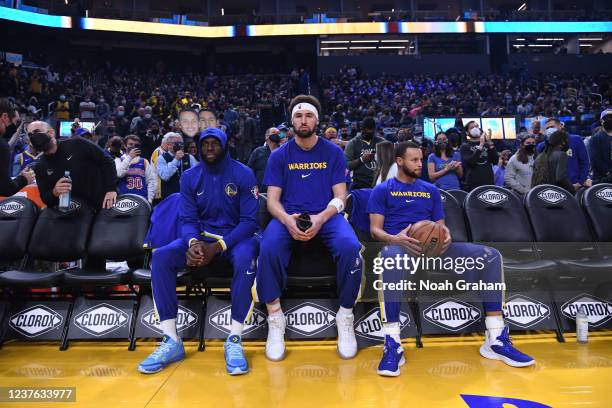 Draymond Green, Klay Thompson, and Stephen Curry of the Golden State Warriors look on before the game against the Cleveland Cavaliers on January 9,...