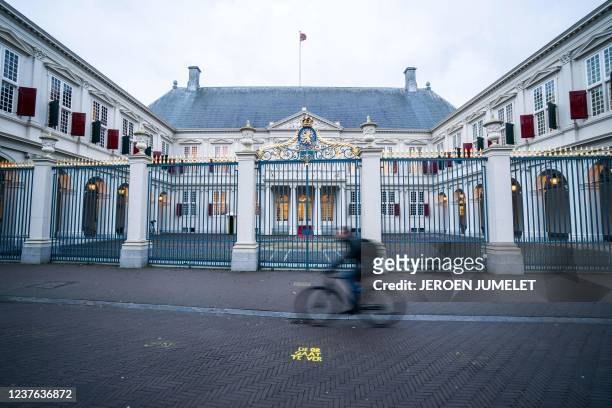 Man cycles past the Noordeinde Palace, in The Hague, on January 10, 2022 ahead of the swearing-in ceremony of the new Dutch four-party coalition...