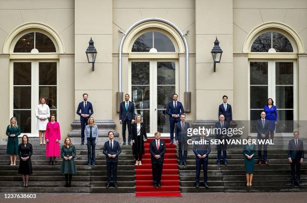 King Willem-Alexander poses with Dutch Prime Minister Mark Rutte and his new IV cabinet outside the Noordeinde Palace in The Hague, on January 10,...