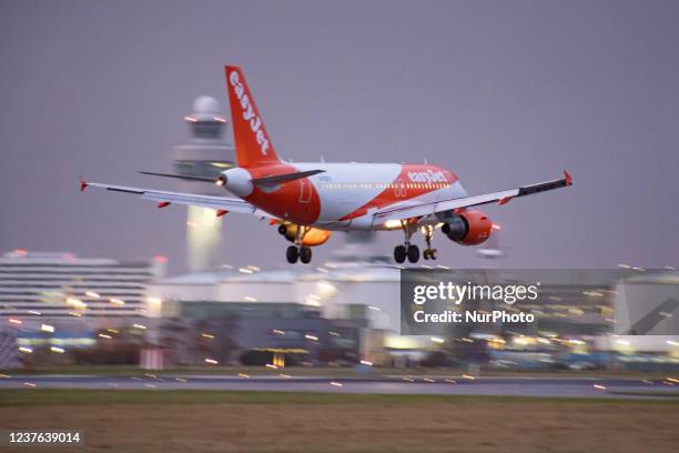 EasyJet Airbus A319 aircraft as seen on final approach flying and landing at Amsterdam Schiphol Airport AMS EHAM with the control tower and the...