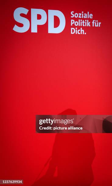 January 2022, Berlin: The shadow of Kevin Kühnert, SPD secretary general, is seen on the background wall during a press conference at the SPD party...