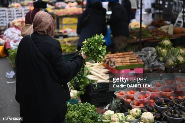 Customer shops for produce at the Whitechapel market in east London on January 10, 2022. - UK annual inflation rocketed last November to 5.1 percent,...
