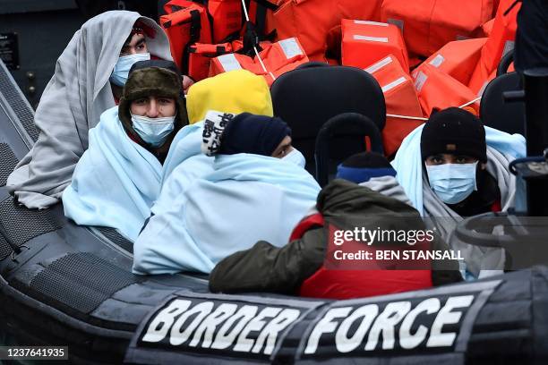 Migrants picked up at sea while attempting to cross the English Channel, are pictured on a UK Border Force patrol boat on arrival at the Marina in...