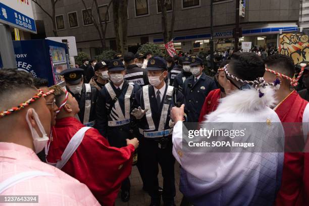 Police officers calm down participants of Seijinshiki in Yokohama Arena. The Japanese celebrate crossing the threshold into adulthood with...