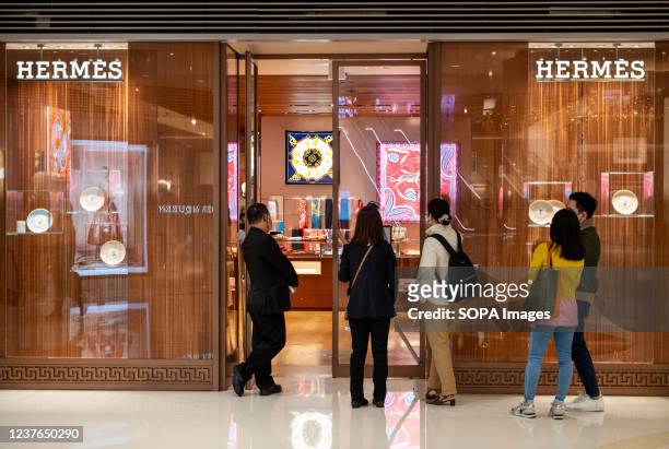 Shoppers queue to enter the French high fashion luxury clothing manufacturer Hermes store in Hong Kong.