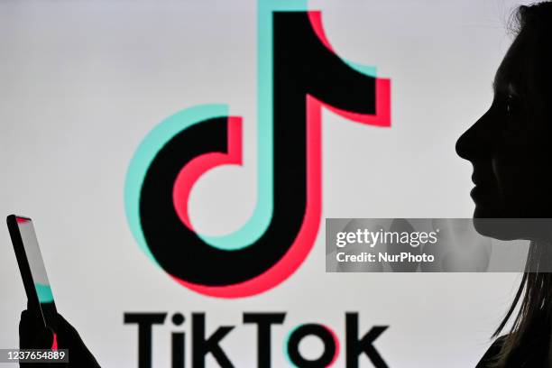 An image of a woman holding a cell phone in front of a TikTok logo displayed on a computer screen. On Tuesday, January 12 in Edmonton, Alberta,...