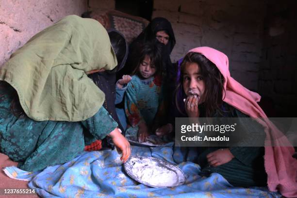 Afghan children eat flour as the poverty rate has increased in Herat, Afghanistan on January 11, 2022. Afghan father Mir Hamza Musazey, Afghan mother...