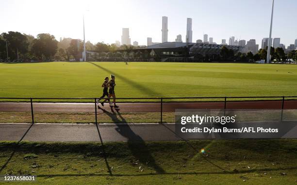 Bella Smith of the Magpies and Tarni Brown of the Magpies are seen jogging laps of the oval during the Collingwood training session at the Holden...