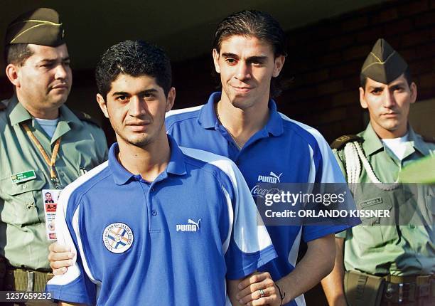 Pedro Benitez and Daniel Sanabria of the Paraguayan soccer team change jerseys under the watch of Colombian police, during a team practice in Cali,...