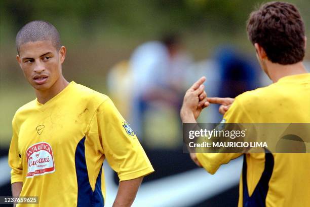 Brazilian forward Alex listens as teammate Juninho Pernambucano issues instructions, 22 July 2001 at a training session in Cali, Colombia. Brazil is...