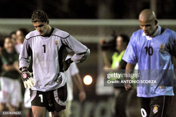 Uruguayan goalkeeper Gustavo Munua and teammate Ruben Olivera leave the field after their defeat 2-1 in their semifinal match against Mexico at the...