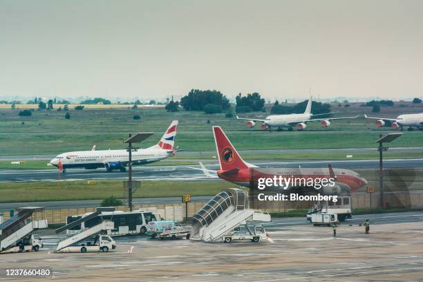 British Airways Plc, left, and a Linhas Aereas de Angola SA passenger aircraft on the tarmac at O.R. Tambo International Airport in Johannesburg,...