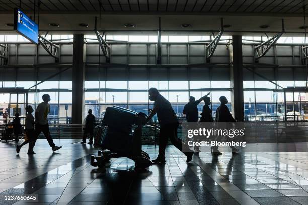 Passenger wheels a luggage trolley inside the departures terminal at O.R. Tambo International Airport in Johannesburg, South Africa, on Tuesday, Jan....