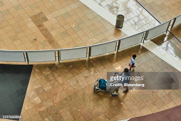 Passenger wheels a luggage trolley inside the departures terminal at O.R. Tambo International Airport in Johannesburg, South Africa, on Tuesday, Jan....
