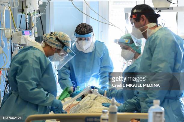 Medical staff members tend to a Covid-19 patient at the intensive care unit of Cremona hospital, in Cremona, northern Italy, on January 11, 2022. -...