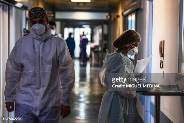 Medical staff members walk in a corridor at the Covid-19 intensive care unit of Cremona hospital, in Cremona, northern Italy, on January 11, 2022. -...