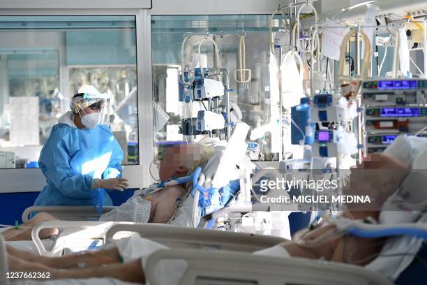 Medical staff member tends to a Covid-19 patient at the intensive care unit of Cremona hospital, in Cremona, northern Italy, on January 11, 2022. -...