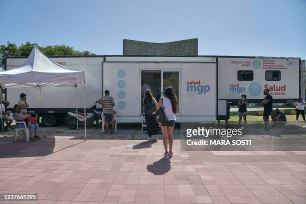 People wait to be tested against COVID-19 outside a municipal health truck in Mar del Plata, Argentina, on January 11, 2022.