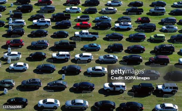Cars line up at a drive-thru COVID-19 testing site at Camping World Stadium. This is the fourth mass testing site that has opened in the area in...