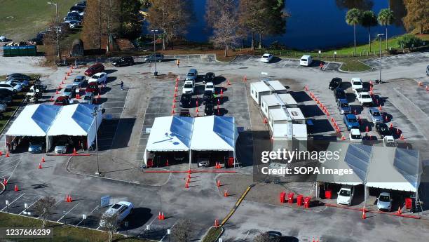 Cars line up at a drive-thru COVID-19 testing site at Camping World Stadium. This is the fourth mass testing site that has opened in the area in...