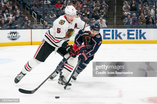 Chicago Blackhawks defenseman Connor Murphy and Columbus Blue Jackets center Sean Kuraly battle for the puck during the game between the Columbus...