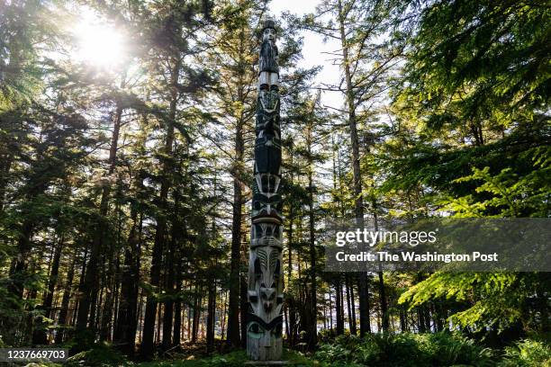 Totem pole stands at the entrance of Náay Iwaans, The Great House/The Whale House, the only traditional Haida longhouse left in America, in the town...