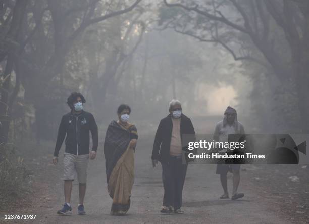 People walk in the morning amid a cold and smoggy weather, at Aarey Colony, Goregaon, on January 11, 2022 in Mumbai, India.