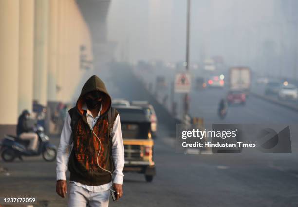 People walk in the morning amid a cold and smoggy weather, at Goregaon, on January 11, 2022 in Mumbai, India.