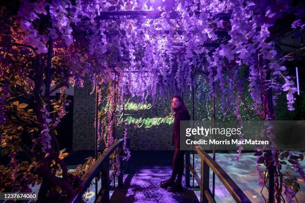 Staff member poses on a garden bridge as part of the "Monet's Garden" exhibition on the opening day at the Alte Muenze venue on January 12, 2022 in...