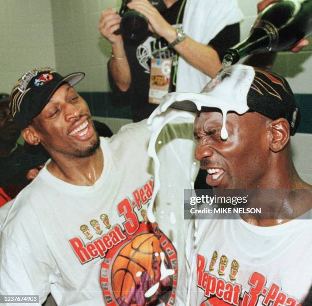 Dennis Rodman of the Chicago Bulls pours champagne on the head of teammate Michael Jordan 14 June after winning game six of the NBA Finals with the...