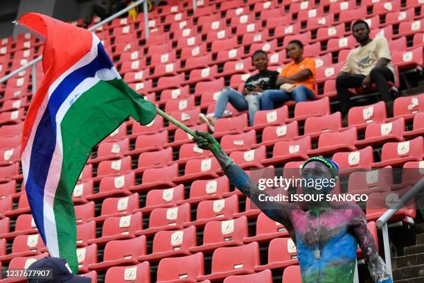 Gambia's supporter waves a flag before the Group F Africa Cup of Nations 2021 football match between Mauritania and Gambia at Limbe Omnisport Stadium...