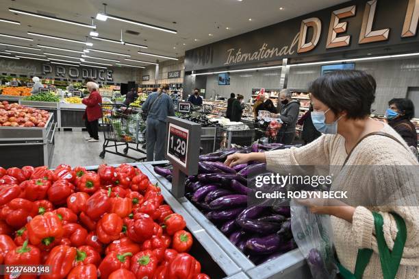 People shop for groceries at a supermarket in Glendale, California January 12, 2022. - The seven percent increase in the Labor Department's consumer...