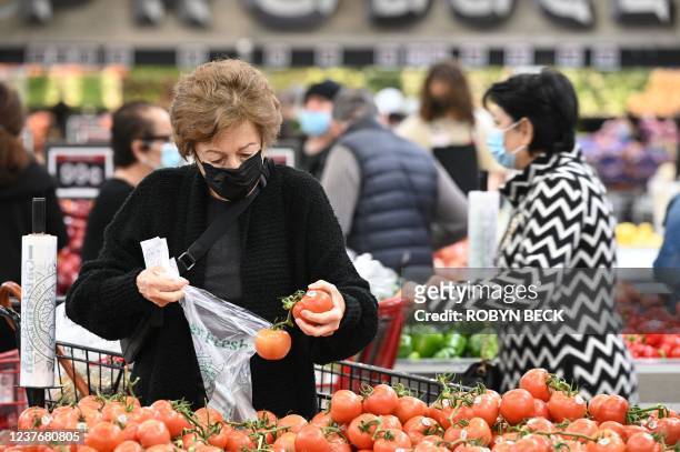 People shop for groceries at a supermarket in Glendale, California January 12, 2022. - The seven percent increase in the Labor Department's consumer...