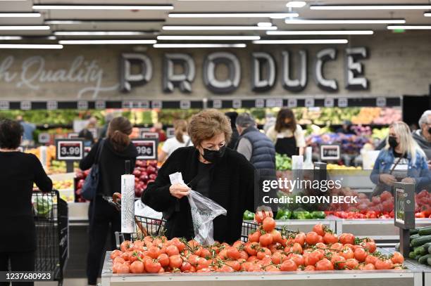 People shop for groceries at a supermarket in Glendale, California January 12, 2022. - The seven percent increase in the Labor Department's consumer...