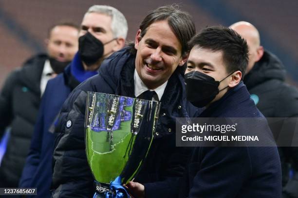 Inter Milan's Italian head coach Simone Inzaghi and Inter Milan's President Steven Zhang hold the Super Cup after Inter won the Italian Super Cup...