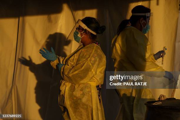 Healthcare workers are pictured at a drive-thru Covid-19 testing site in El Paso, Texas on January 12, 2022. - The country is currently seeing an...
