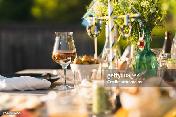 glass of rosé wine at midsummer dinner - midsommar stock pictures, royalty-free photos & images