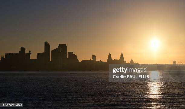 The sun rises across the River Mersey over the skyline of Liverpool in northwest England on January 13, 2022.